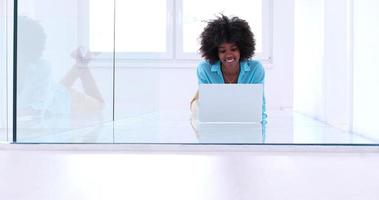 schwarze Frauen mit Laptop-Computer auf dem Boden foto