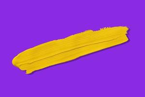 gelber Pinsel und Schatten isoliert auf violettem Hintergrund foto