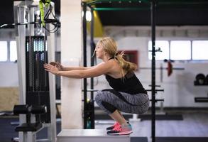 Frau, die beim Springen auf der Fit-Box trainiert foto