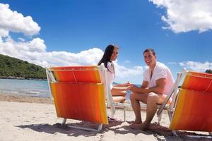 Glückliches Paar hat Spaß am Strand foto