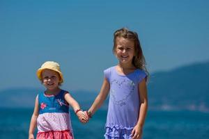 kleine Schwestern, die an der Strandküste spazieren gehen foto