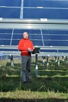 Ingenieur mit Laptop auf dem Feld der Solaranlage foto