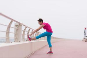 Frau, die sich auf der Promenade ausdehnt und aufwärmt foto