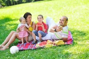 glückliches junges Paar mit ihren Kindern haben Spaß im Park foto