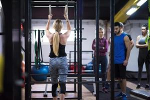 frau, die mit persönlichem trainer an gymnastikringen trainiert foto