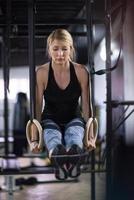 Frau trainiert Klimmzüge mit Gymnastikringen foto