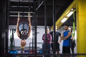 frau, die mit persönlichem trainer an gymnastikringen trainiert foto