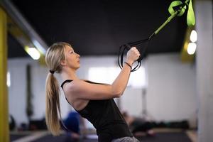 Frau trainiert Klimmzüge mit Gymnastikringen foto