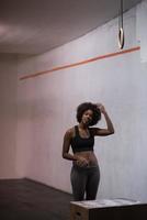 Schwarze Sportlerin führt Boxsprünge im Fitnessstudio durch foto
