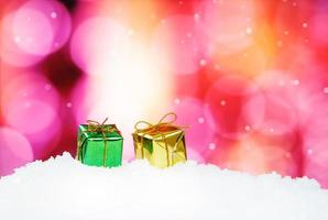 Geschenkbox und Weihnachtsdekoration auf abstraktem Hintergrund und Schneeflocken foto