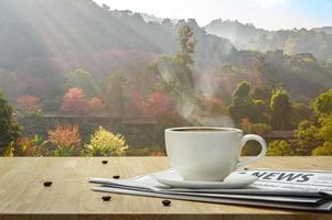 Kaffeetasse mit Zeitung auf dem Holztisch und dem Sakura-Hintergrund foto