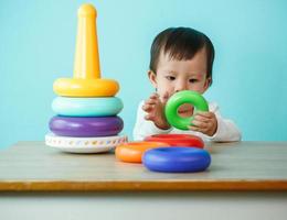 Baby spielt mit Lernspielzeug auf blauem Hintergrund foto