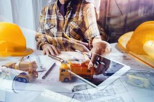 Business-Handarbeit und Laptop mit einem Architekturprojekt auf der Baustelle am Schreibtisch im Büro foto