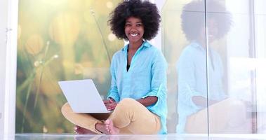 schwarze Frauen mit Laptop-Computer auf dem Boden foto