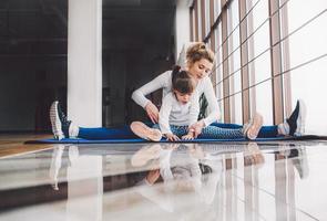 mutter und tochter umarmen und dehnen sich im fitnessstudio foto