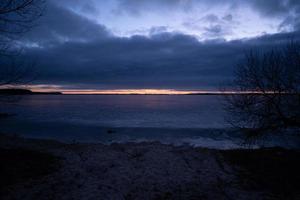 schöner kalter sonnenaufgang über einem zugefrorenen see foto