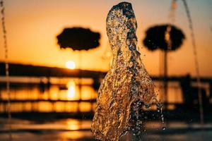 strom eines brunnens spritzt wasser, sonnenuntergang foto