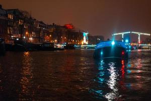 Nachtbeleuchtung von Gebäuden und Booten im Kanal. foto