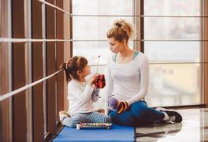 Mutter und Tochter spielen mit Spielzeug im Fitnessstudio foto