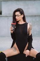 Frau in einer sexy Position trinkt Straßenkaffee. foto