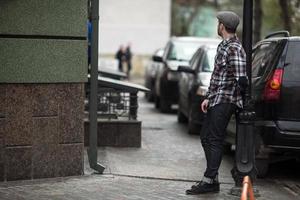 der Mann in den authentischen Stiefeln und Webkantenjeans vor dem Hintergrund der Altstadt foto