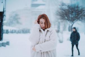 Frau draußen an schneiendem kalten Wintertag foto