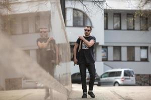 der Mann in den authentischen Stiefeln und Webkantenjeans vor dem Hintergrund der Altstadt foto