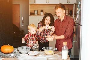 Vater, Mutter und kleiner Sohn kochen einen Kuchen foto