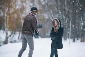 Mann und Frau werfen Schneebälle foto