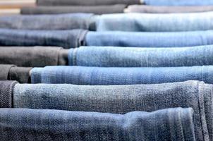 viele bunte Jeans hängen an Kleiderbügeln foto