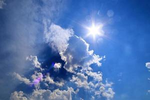 schöne aussicht auf sonnenstrahlen mit einigen linseneffekten und wolken am blauen himmel foto