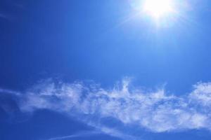 schöne aussicht auf sonnenstrahlen mit einigen linseneffekten und wolken am blauen himmel foto