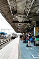 der zug, der am gleis ankommt, unbekannte menschen warten auf den zug am bahnhof ludhiana foto