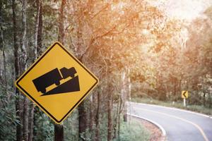 Verkehrszeichen, Vorsicht vor Lastwagen auf einer kurvigen Straße foto