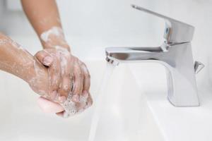 Hygiene. Hände reinigen. Händewaschen mit Seife unter dem Wasserhahn mit Wasser zahlen Schmutz. foto