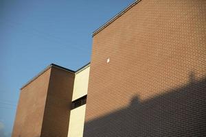 Die Fassade des Gebäudes in der Stadt vor dem Hintergrund eines strahlend blauen Himmels. sonnenlicht, mauerwerksbeschaffenheit. Stadtarchitektur in Russland. foto