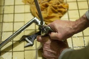 Reparatur von Sanitär. Klempner repariert den Wasserhahn in Russland. foto