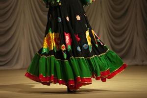 Tanzen Sie in einem Kleid im Stil von Zigeunern. Leistung auf der Bühne. Volkstanz. Tanzstunde. foto
