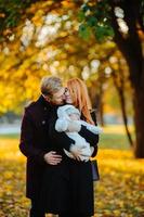 junge Familie und neugeborener Sohn im Herbstpark foto