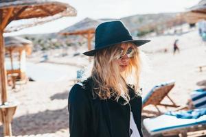 junge Frau mit Strohhut und Sonnenbrille am Strand foto