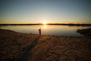 paar im sonnenaufgang am strand foto