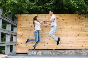 Paar posiert auf einem Hintergrund der Holzwand foto
