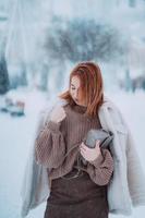 Frau draußen an schneiendem kalten Wintertag foto