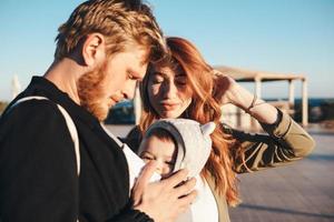 glückliche, fröhliche junge Familie im Sommerpark foto