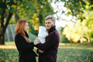 junge Familie und neugeborener Sohn im Herbstpark foto