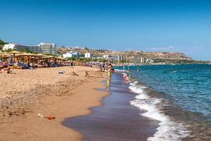 Menschen entspannen am Sandstrand im Resort Faliraki auf der Insel Rhodos, Griechenland foto