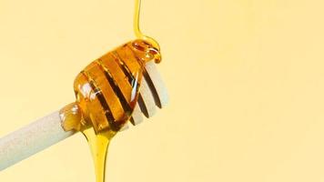 Honig wird auf eine Schöpfkelle gegossen. gesundheits- und schönheitsprodukt nachhaltiges lebensstilkonzept. Nahaufnahme mit Kopierbereich. foto