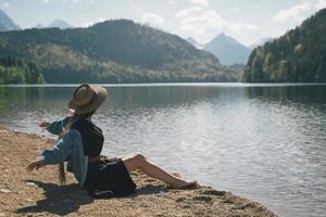 das mädchen im kleid und hut des sees in den bergen foto