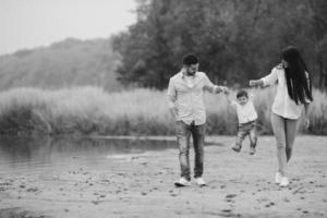 junge Familie, die am Strand spazieren geht foto