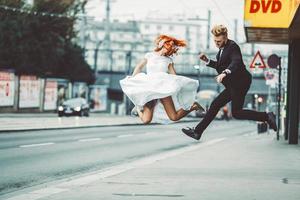 Hochzeitspaar springt in die Stadt foto